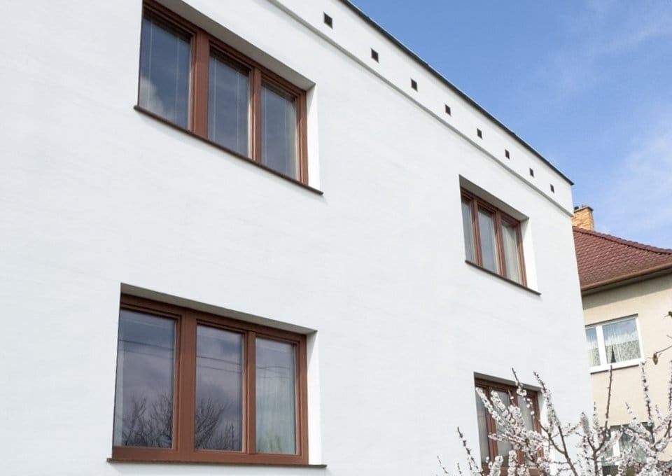 Fehér homlokzat sötét alumínium borítású ablakokkal